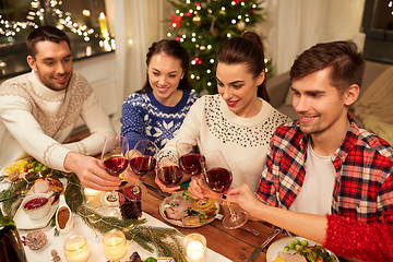 Image showing friends celebrating christmas and drinking wine