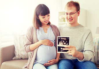 Image showing happy couple with ultrasound images at home