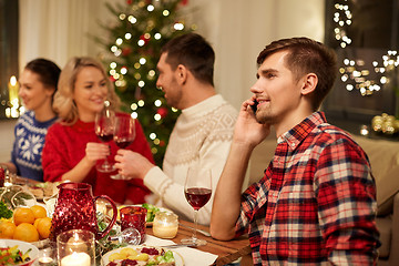 Image showing man calling on smartphone at christmas dinner