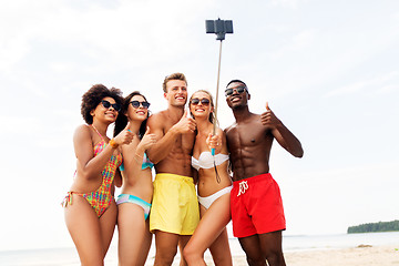Image showing friends taking selfie on beach and show thumbs up
