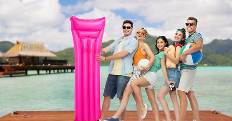 Image showing happy friends with beach accessories on bora bora