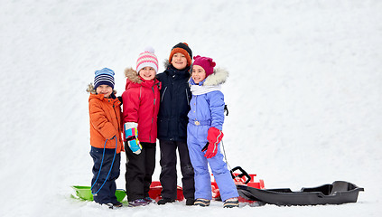 Image showing happy little kids with sleds hugging in winter