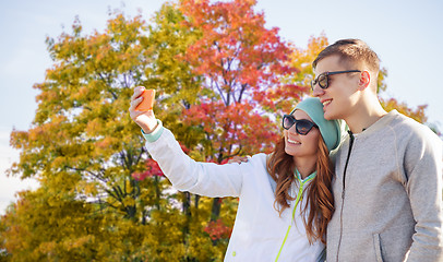 Image showing couple taking selfie by smartphone in autumn park