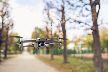 Image showing Drone flying in the air in the park alley