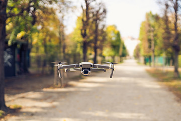 Image showing Drone flying in the air in the park alley