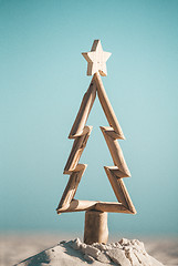 Image showing Rustic timber driftwood Christmas tree in sand by the beach