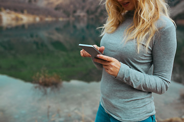 Image showing Woman using smartphone at the lake