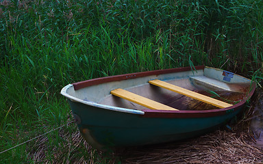 Image showing Old Metal Rowing Boat Among The Reeds In The Twilight