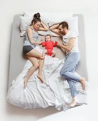 Image showing Top view of happy family with one newborn child in bedroom.