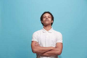 Image showing Suspiciont. Doubtful pensive man with thoughtful expression making choice against blue background