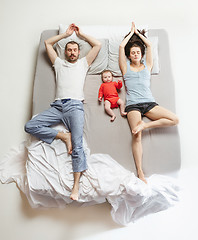 Image showing Top view of happy family with one newborn child in bedroom.