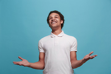 Image showing The happy business man standing and smiling against blue background.