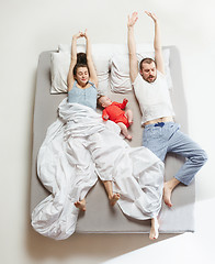 Image showing Top view of happy family with one newborn child in bedroom.