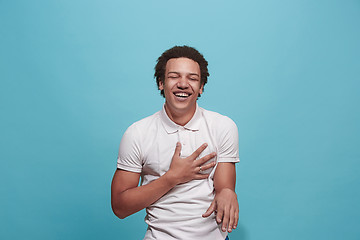 Image showing The happy business man standing and smiling against blue background.