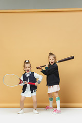 Image showing Portrait of two girls as tennis players holding tennis racket. Studio shot.