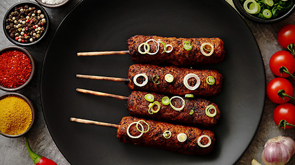 Image showing Barbecued turkey kebab decorated with fresh onion