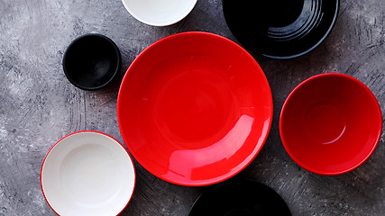 Image showing Collection of empty colorful decorative ceramic bowls on grey stone background.