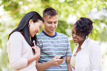 Image showing group of happy friends with smartphone outdoors