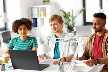 Image showing happy creative workers with laptops at office