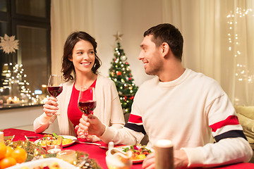 Image showing happy couple drinking red wine at christmas dinner