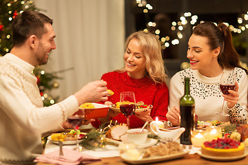 Image showing happy friends having christmas dinner at home