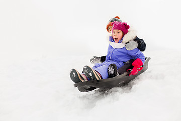 Image showing kids sliding on sled down snow hill in winter