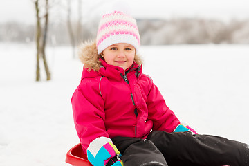 Image showing happy little girl on sled outdoors in winter