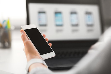 Image showing web designer with smartphone and laptop at office