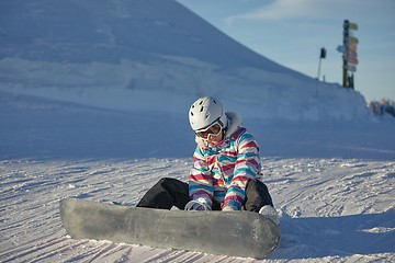 Image showing Snowboarder sitting in the snlow
