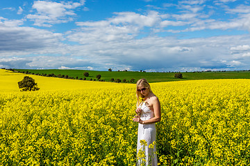 Image showing Woman stands in field of canola rural Australia