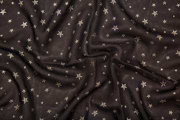 Image showing Black silky fabric with glittering metallic stars