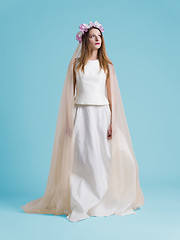 Image showing beautiful woman wearing wedding dress against cyan background