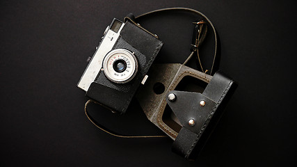 Image showing Old retro film camera in leather case on black background