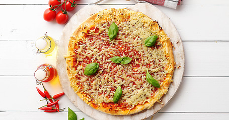 Image showing Delicious italian pizza served on wooden table, shot from above