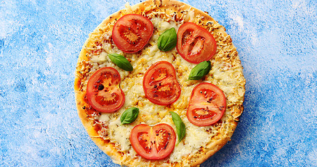 Image showing Pizza with cheese and tomatoes on blue stone table
