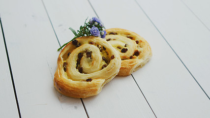 Image showing Delicious pastry with raisins on white wooden table