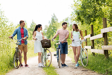 Image showing happy friends with fixed gear bicycles in summer