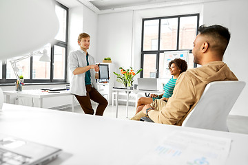 Image showing man showing tablet pc to creative team at office