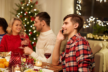 Image showing man calling on smartphone at christmas dinner