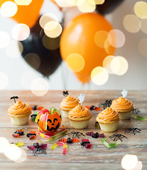 Image showing halloween party decorated cupcakes on wooden table