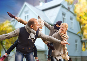 Image showing happy family having fun over house in autumn