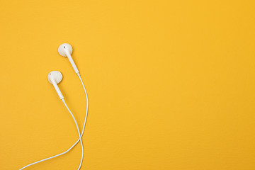 Image showing White earphones on yellow background with space for text