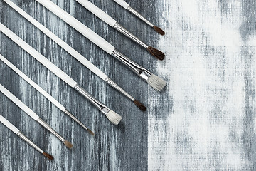 Image showing Paintbrushes on artistic background with gray brush strokes