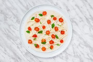 Image showing Preparing a tortilla with tomatoes, cheese and basil