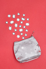 Image showing Silver purse and sparkling gemstones on pink background