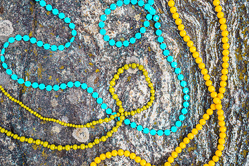 Image showing Colorful necklaces on mossy rock background