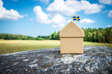 Image showing Cardboard house with Swedish flag on a mossy rock