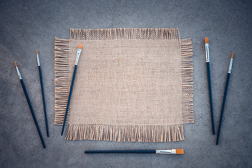 Image showing Paintbrushes and canvas on concrete background