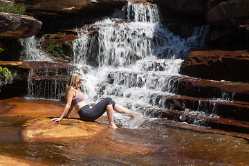 Image showing Female splashing her feet in cascading waterfall