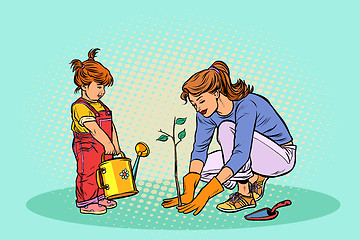 Image showing mother and daughter working in the garden, planting a seedling